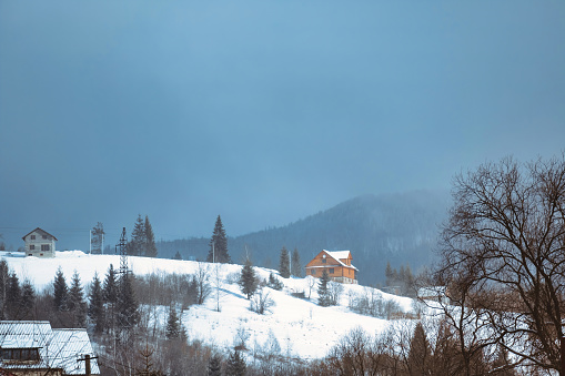 Winter scene house on mountains landscape. Stone snowy mountains. download image