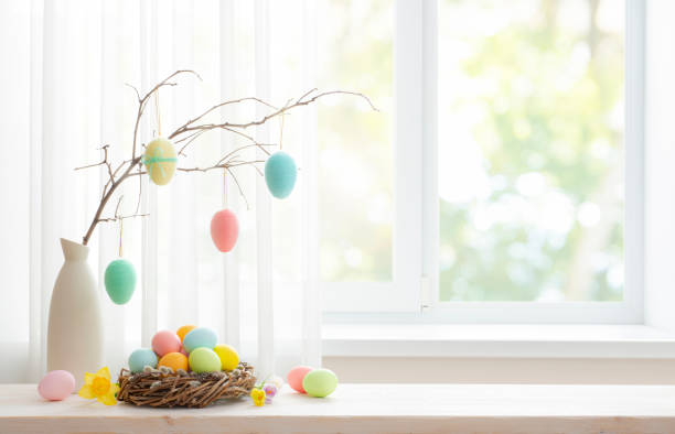 istock Vase with colorful easter eggs hanging on spring branch and pussy willow nest on table 1997771889