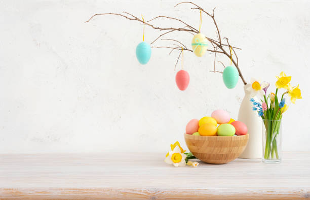 istock Colorful easter eggs on twig in vase and bowl on table with spring flowers 1997771895