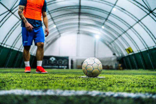Soccer player goes towards the ball on an indoor court