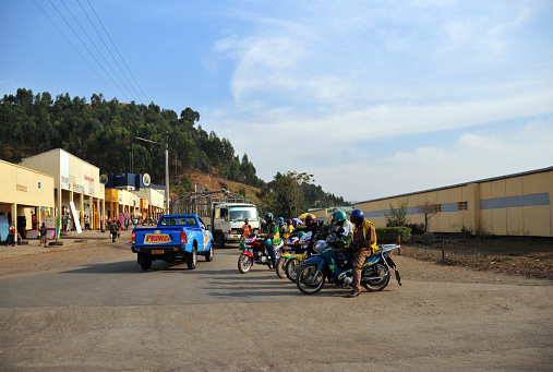 Ruhengeri, Musanze District, Northern Province, Rwanda: informal transportation - group of motorcycle taxis drivers stand near a commercial area waiting for passengers. Boda-Boda.