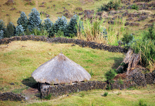 Kimonyi, Musanze District, Northern Province, Rwanda: farmer's house - traditional Rwanda rural round hut surrounded by a stone wall.