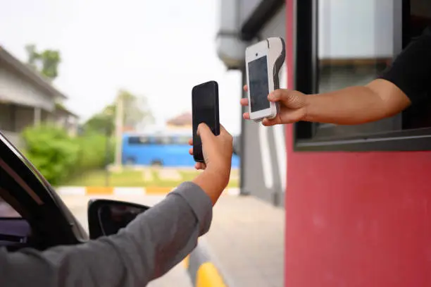 Photo of Men scan and pay for food, pick up food from a drive-thru counter and take it to eat at home and at work.