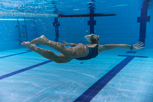 Underwater photo, girl swimming in a sports pool, side view. Underwater photo.