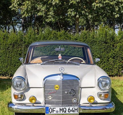 Weiterstadt, Germany September 24, 2023: Mercedes Benz series 110 in white at Chromblitz in Weiterstadt at Braunshardt Castle; spoke rims