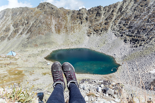 Personal perspective of woman  relaxing on top of Rila Mountain . Feet view . Travel vacations concept