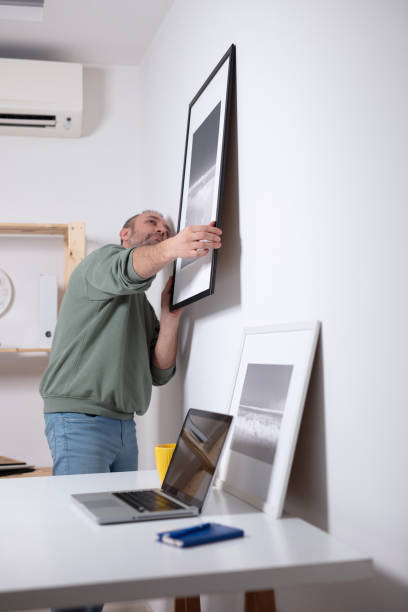 istock Man hanging pictures on the wall. 1997991279