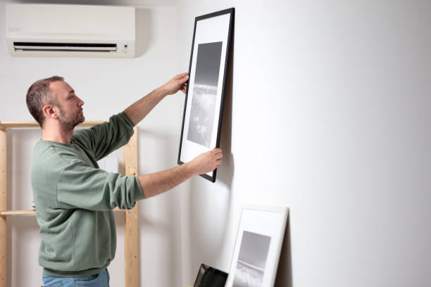 istock Man hanging pictures on the wall. 1997991801