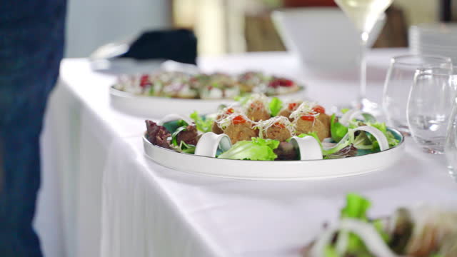 Luxury catering service table on exit party outdoors at restaurant reception, arranged buffet table with food trays and drinking goblets, assortment of appetizers, snacks and canapes for invited guests