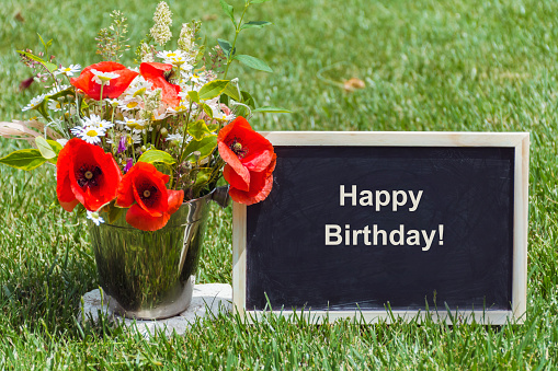 Birthday card with Poppy flowers Bouquet on a Green Grass
