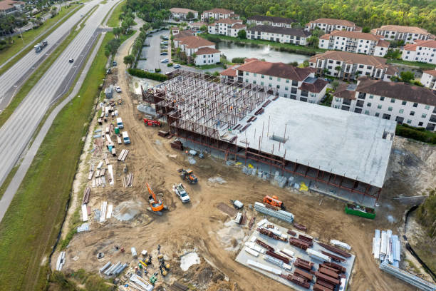 istock Construction site with hardhat workers assembling metal frame walls. Aerial view of large development area of commercial structure. Real estate market in the USA 1998007689