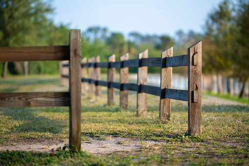 Wooden fence barrier at farm grounds for cattle and territory protection.
