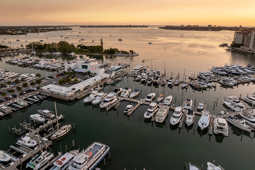 Sarasota, Florida at sunset. Luxury yachts docked in Sarasota Bay marina. American city downtown architecture with high-rise office buildings. USA travel destination.