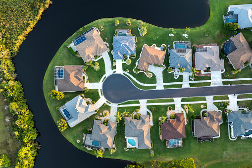 View from above of residential houses in living area in North Port, FL at evening. Illuminated American dream homes as example of real estate development in US suburbs.