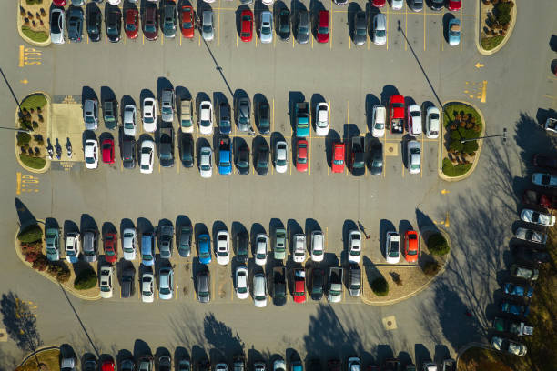 view from above of many parked cars on parking lot with lines and markings for parking places and directions. place for vehicles in front of a strip mall center - strip mall shopping mall road street zdjęcia i obrazy z banku zdjęć