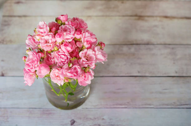 istock Pink Roses bouquet on wooden background 1998044400
