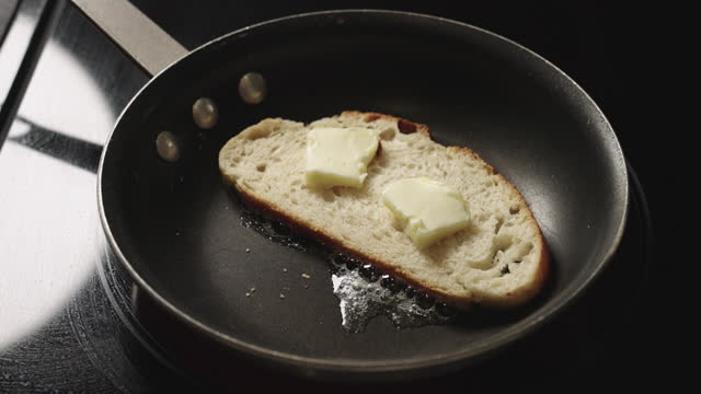Toasted Slice of SourDough Bread In a Pan with Butter, Toasting to a Golden Brown