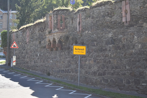 Bacharach, Germany - 09/05/2023: town sign of Bacharach at city walls and railroad
