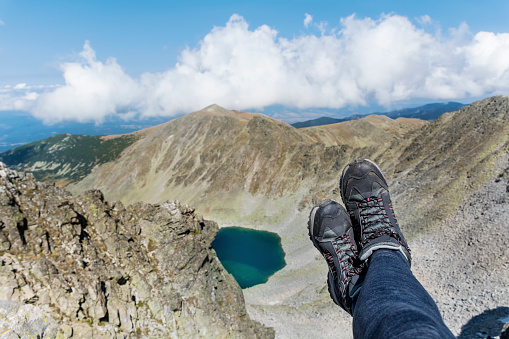 Personal perspective of woman  relaxing on top of Rila Mountain . Feet view . Travel vacations concept