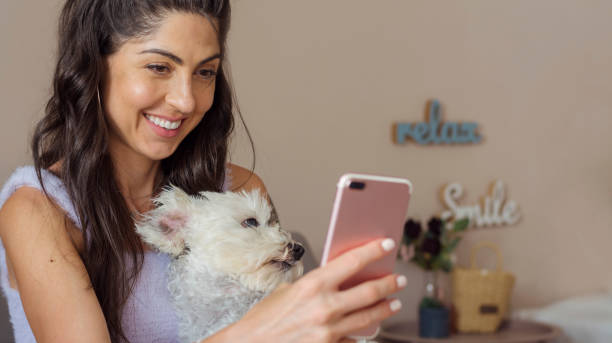 istock Smiling Woman using her phone at home 1998068456