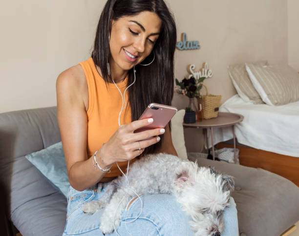 istock Smiling Woman using her phone at home 1998069434