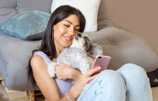 istock Smiling Woman using her phone at home 1998069988