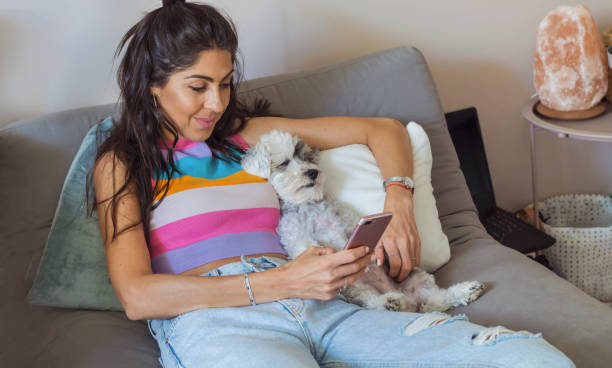 istock Smiling Woman using her phone at home 1998071151