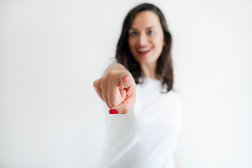 woman pointing finger at camera on white