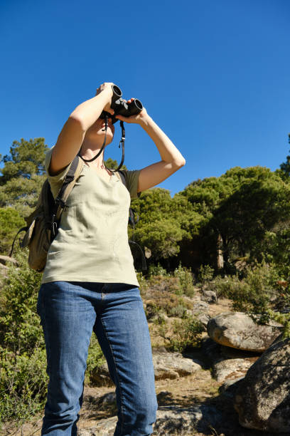 istock Women tourist exploring nature with binoculars in forest 1998081039