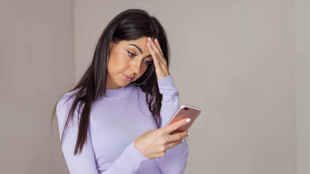 istock Sad Woman  using her phone at home 1998084918