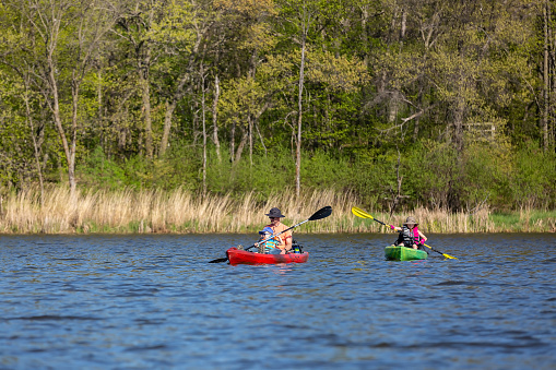 Family kayaking at Lake Maria State Park in Minnesota, USA, on a beautiful springtime day.