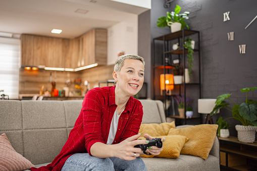 Caucasian woman having fun playing video games at home