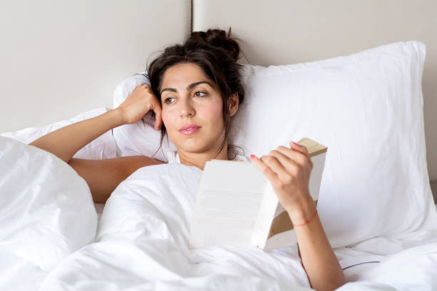 istock Woman  reading book in the bed 1998097750