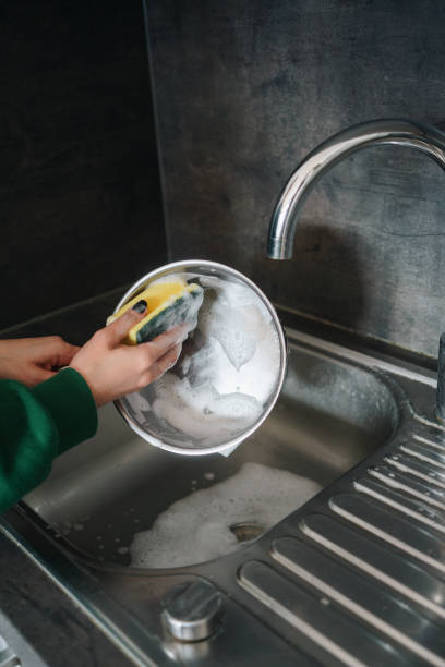 istock Woman washing a pan with a sponge in the kitchen 1998104162