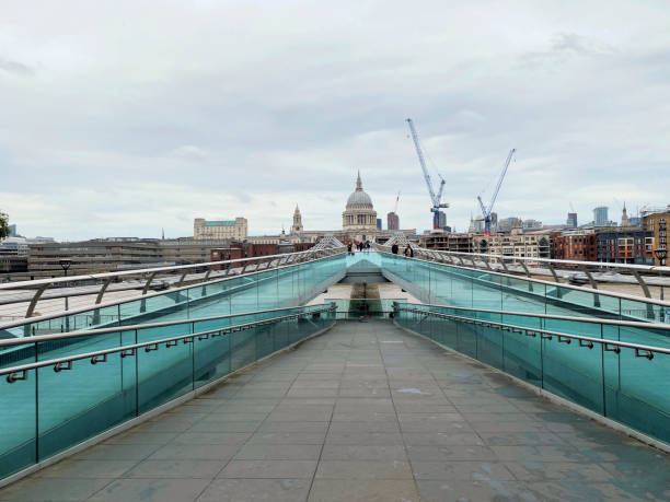 London business people on way home after a days work and crossing the Millennium Bridge. A filter used to keep the background sharp but blur the commuters.