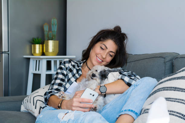 istock Smiling Woman using her phone at home 1998144774