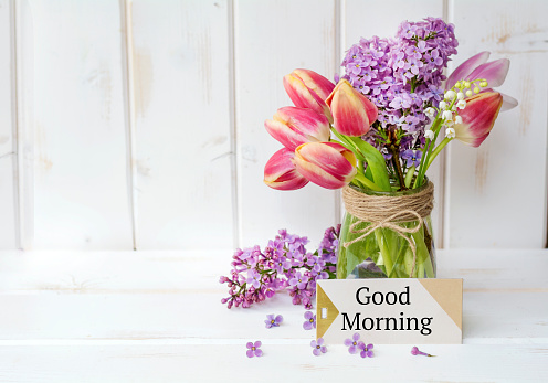 Good morning message with tulips and lilac flowers in vase