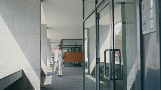 istock Busy executive manager walking on office building talking phone. Girl calling 1998181013