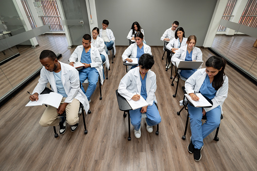 Group of Latin American medical students taking an exam in a classroom - education concepts