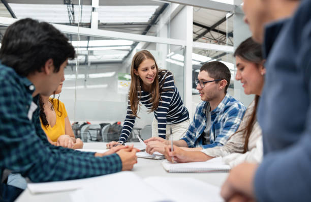 istock Happy students in class sharing ideas in the classroom 1998218867