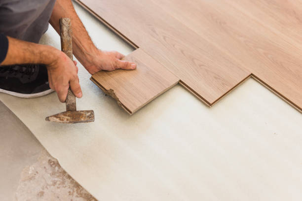 istock Man using hammer when positioning hardwood floor tiles 1998219408