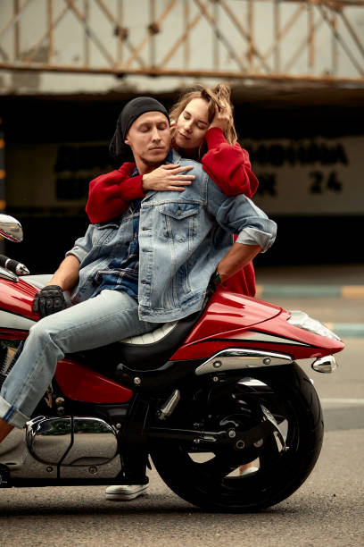 istock A young couple of bikers sits hugging on a motorcycle. 1998241635