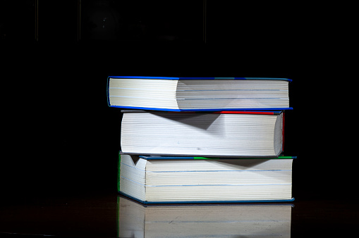 Stack of three books on black background