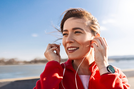 Fit sportswoman wearing headphones taking a break