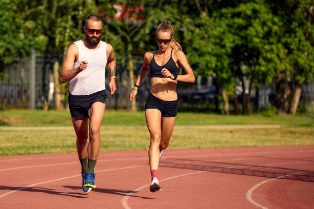 istock Woman and man jogging in the stadium 1998266121