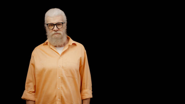 istock A displeased senior man standing against a black background, providing space for your text 1998268203