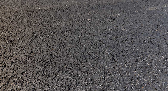 asphalting a new highway with black new asphalt, a close-up of a part of a new paved road