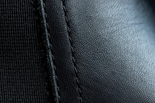 a black leather object sewn from several parts, part of a shoe made of different pieces of black leather