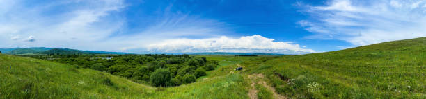 istock Panorama of green meadow and blue sky with white clouds. 1998293239