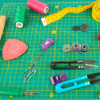 A set of sewing accessories laid out on a patchwork mat.